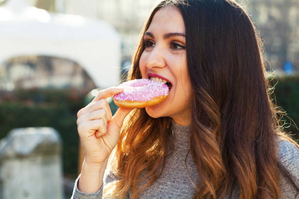 istock Young woman eating a donut 1310169774