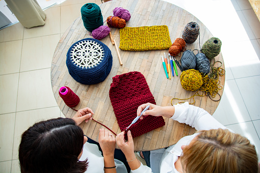 Top view of women knitting together at home