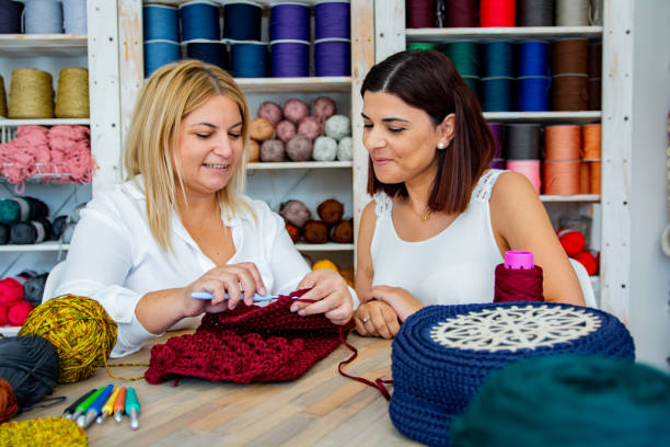 femmes de sourire tricotant et crochetant à l’atelier d’art et d’artisanat - arts and crafts movement photos et images de collection