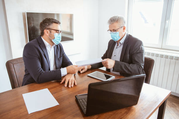 istock Two businessmen wearing protective face masks and work together 1310174602