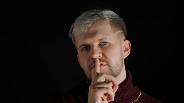 istock Strict serious man asking to stay calm, keep silence or secrecy with finger on lips shh gesture 1310174646