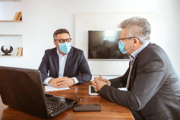 istock Two businessmen wearing protective face masks and work together 1310174658