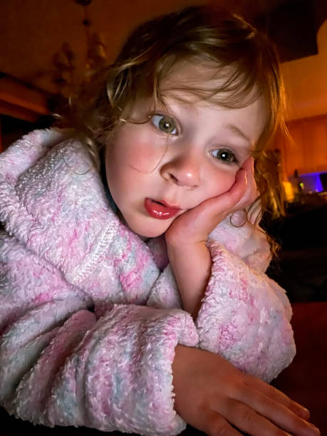 istock Toddler girl in bathrobe looking at digital tablet 1310177403