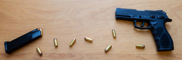 istock firearm, 40 caliber pistol in ammunition on wooden surface. 1310178214