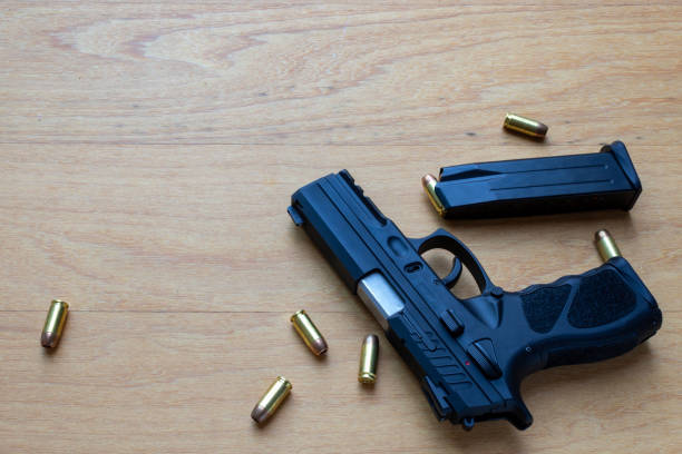 istock firearm, 40 caliber pistol in ammunition on wooden surface. 1310178292