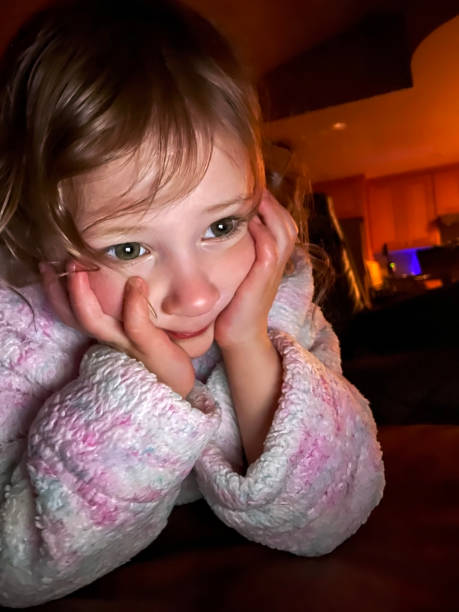 istock Toddler girl in bathrobe looking at digital tablet 1310180576