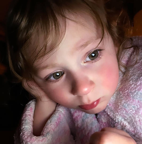 istock Toddler girl in bathrobe looking at digital tablet 1310180598