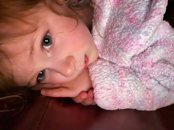 istock Toddler girl in bathrobe looking at digital tablet 1310180602