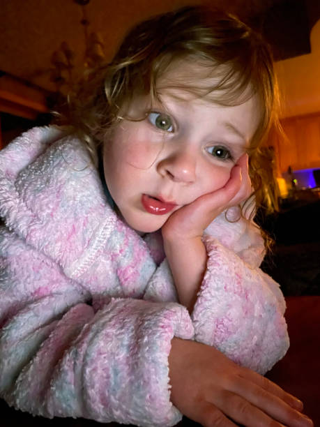 istock Toddler girl in bathrobe looking at digital tablet 1310180629