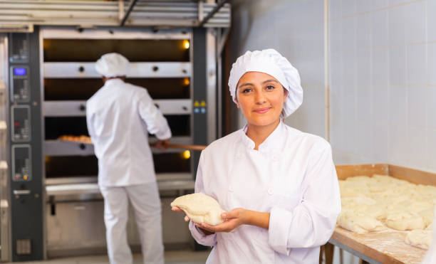 istock Woman baker demonstrates ready dough for baking in oven 1310180686