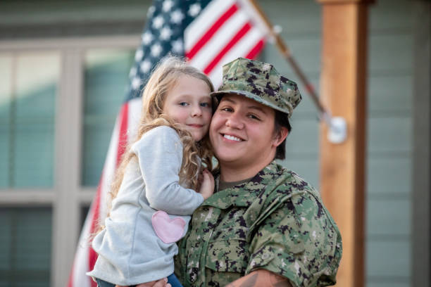 istock Mother holds elementary age daughter in front yard after arriving home from deployment 1310183551