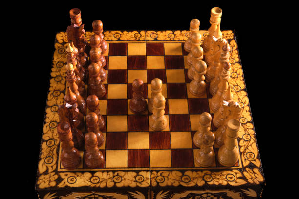 istock Chessboard with Queen Gambit opening on black background, carved chess 1310183709