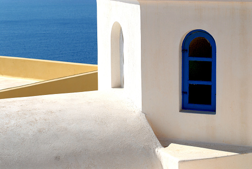 A close up view of traditional architecture angles and aspects with the blue sea in the background.  Shot in Santorini Greece.