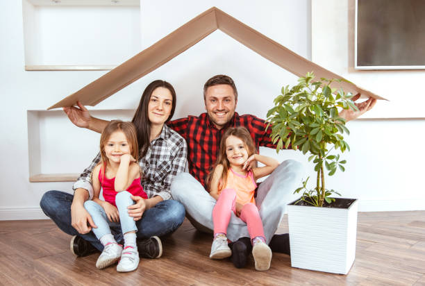 istock Smiling family holding cardboard roof 1310188193