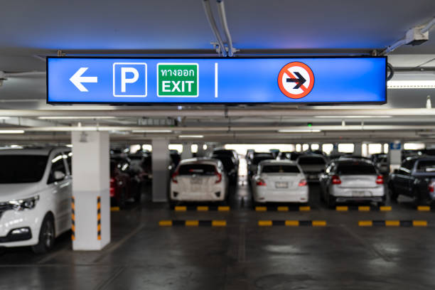 istock Signage Lightingbox in the indoor carparking, tell driver which way is parking lot or exit. Thai Language in green square on lightinbox means EXIT. 1310189119