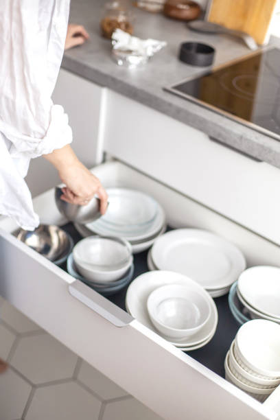 istock Comfortable white gray kitchen interior open box full of various crockery porcelain or glass plates 1310190243