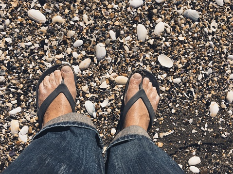 greek model advertises bohemian sandals on the beach - summer fashion