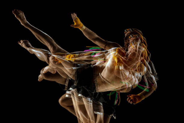istock Young man thai boxer training over dark background in neon mixed light. 1310191312