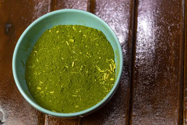 Photo of Mate herb (Ilex paraguariensis) ground in a ceramic container for culinary and medicinal use.