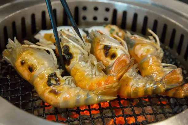 Photo of Fresh shrimp is grilled on a charcoal stove