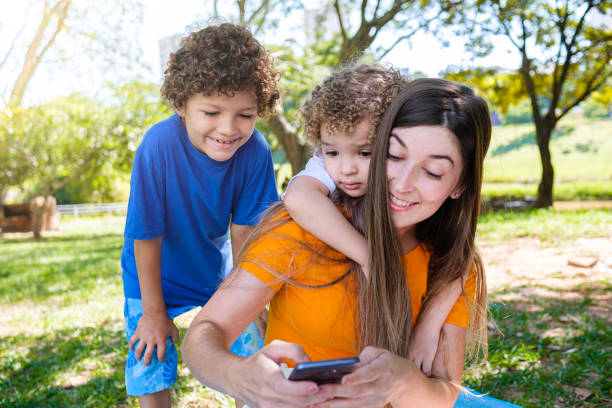 istock Children with mother using technology during a break in the park 1310199092