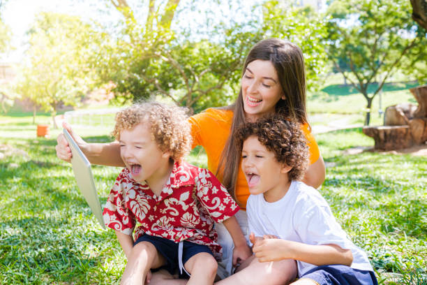 istock Family in park making video call with portable technology 1310199108