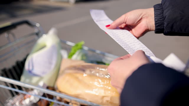 Woman housewife looking check after shopping on parking lot