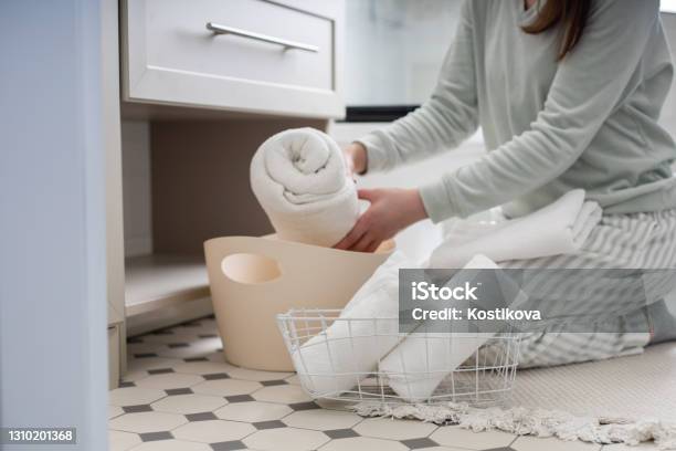 Smiling Housewife Rolled Up Bath Towel Organizing Storage In Closet Under Sink Marie Kondos Method Stock Photo - Download Image Now