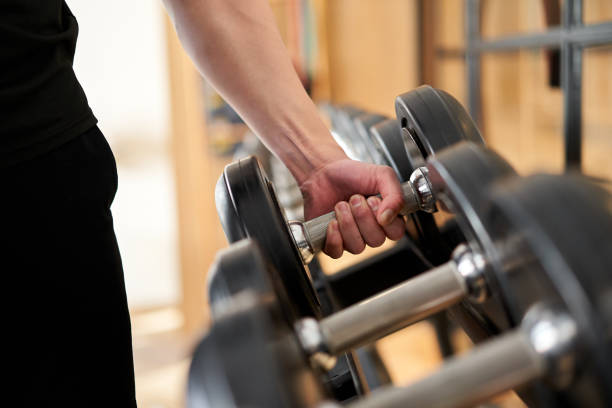 istock Hands of an Asian man taking dumbbells from a rack 1310204014
