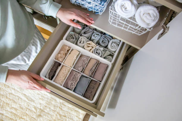 istock Top view female hands holding organizer drawer divider with socks storage Marie Kondo's method 1310205954
