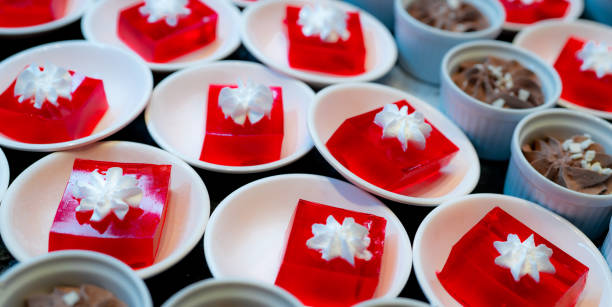 dessert de gelée rouge avec la crème fouettée servie sur l’assiette blanche. gelée rouge carrée dans l’assiette sur la table au restaurant pour le buffet de déjeuner. de la nourriture sucrée. un agar à la gelée. concept de restauration de buff - agar jelly photos et images de collection