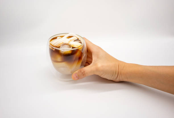 istock Hand holding iced coconut coffee in double walls glass isolated on white background. Selective focus. 1310209064