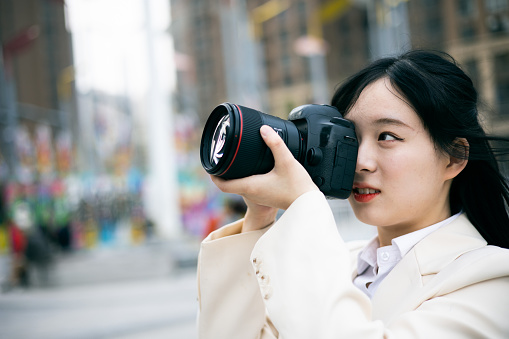 Asian woman taking photos with camera