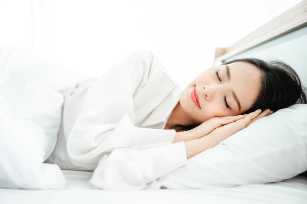 Young asian beautiful woman happy sleep on bed in morning time stock photo