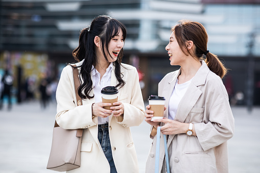 Two young woman talking in the city street