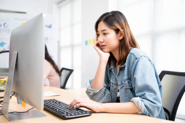 istock Young asian beautiful woman working on computer at workplace with a business team group 1310214863