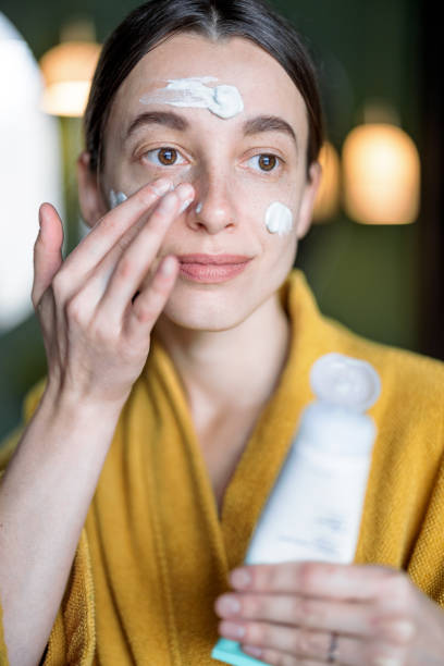 istock Woman applies moisturizer on her face 1310217001