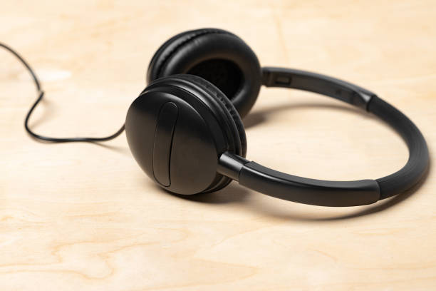 istock Black headphones with wire on wooden background 1310221002