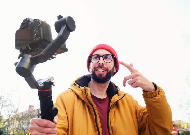 istock videographer recording himself with a dslr camera on a motorized gimbal waves to the camera 1310221152