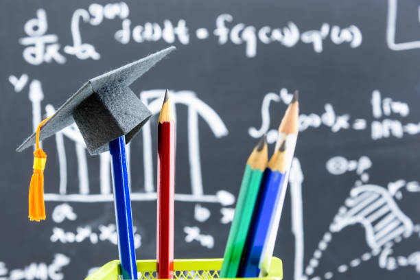 istock Black graduation cap or a mortarboard, blue and red pencils in a bottle 1310221718