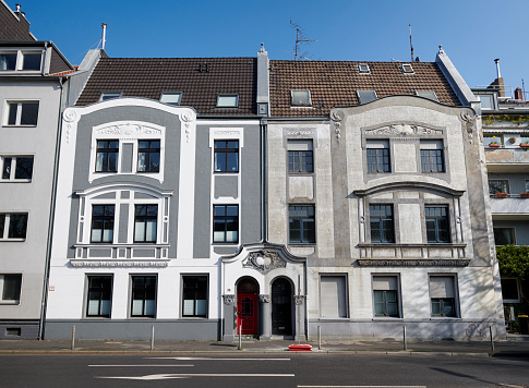 Duesseldorf, Germany - March 24, 2021: Two similar townhouses from the beginning of the 20th century, one recently renovated, one in bad conditions.