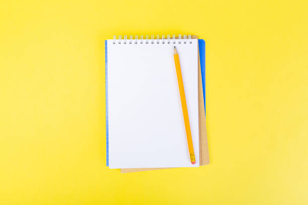 istock open notepad on yellow background with pencil on top, spiral notepad with blank sheet. top view of school concept, work desk of businessman. 1310222057