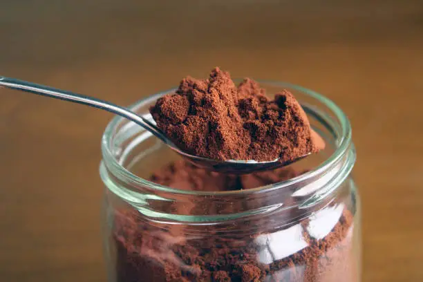 Ground coffee in the jar and spoon, close up coffee powdered