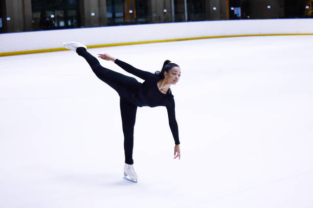Some reach for the stars, others glide across them Shot of a young woman figure skating at a sports arena figure skating stock pictures, royalty-free photos & images