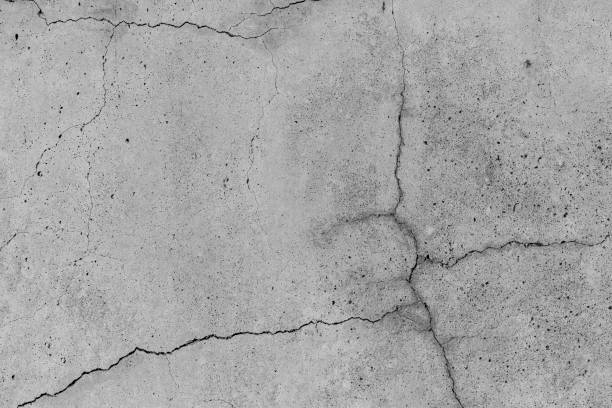 istock Concrete with crack broken in floor wall texture. Chapped surface asphalt old cement stone. Natural destruction from time and weather conditions. Non-color, monochrome black and white photo. 1310223151