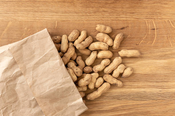 istock Peanuts or groundnuts in shells on wooden background. 1310224846