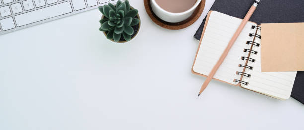 istock Horizontal image of minimal workplace with notebook, coffee cup, keyboard and copy space on white desk. 1310226872