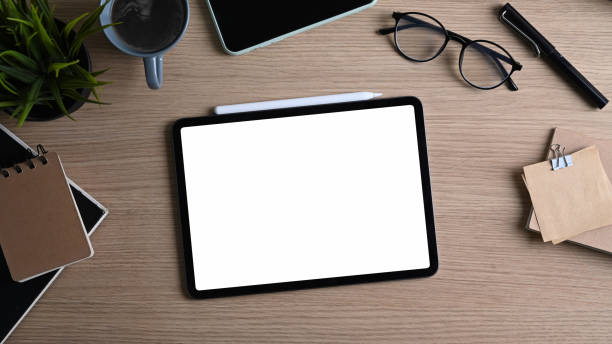 istock Top view of contemporary workplace with digital tablet, glasses, notebook and coffee cup on wooden table. 1310227008