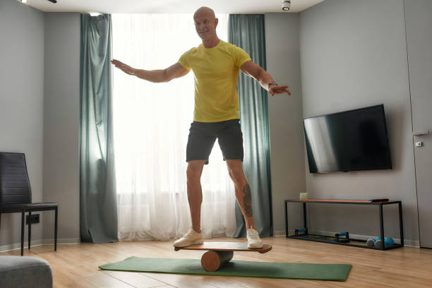 istock Smiling middle aged caucasian man on balance board 1310230466