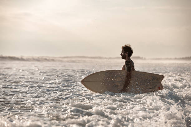 istock Attractive athletic surfer stands in the water 1310234882